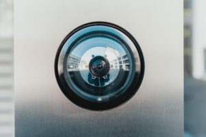 A close-up of a surveillance camera lens. Photo by Bernard Hermant on Unsplash